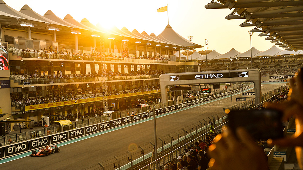 Sunset as a Ferrari drives on pit straight at the Abu Dhabi Grand Prix