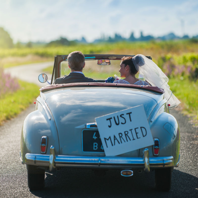 A newlywed couple is driving