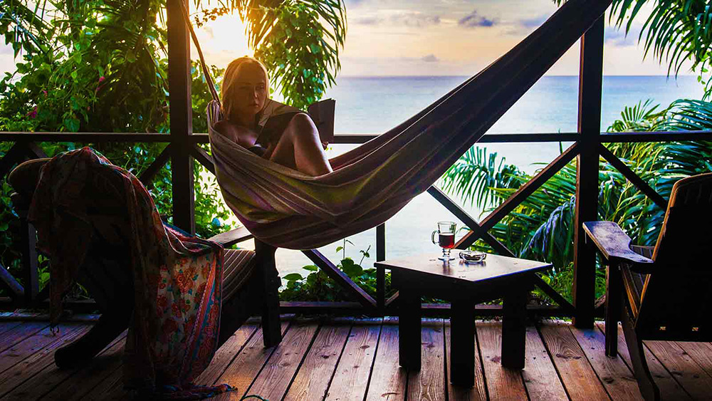 Woman in a hammock on the balcony at Cocos Hotel