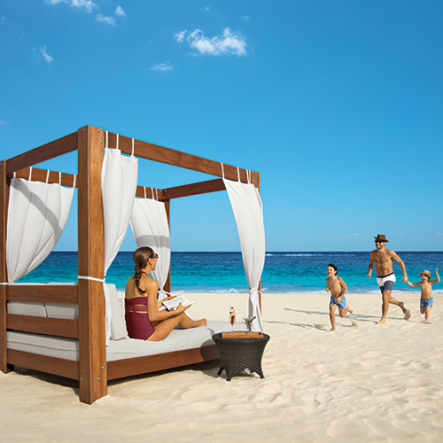 Family on a beach cabana at Dreams Riviera Cancun