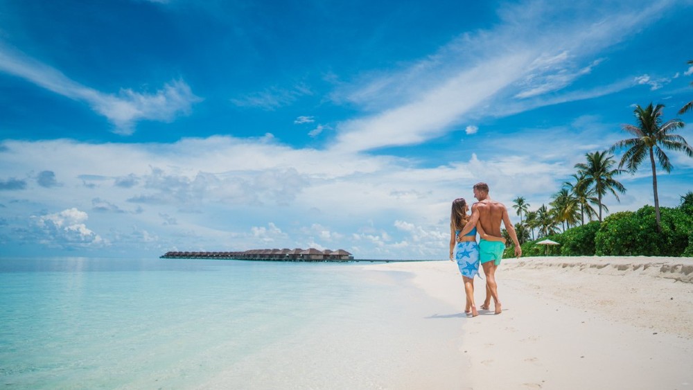 Couple on the beach at Hurawalhi Island Resort