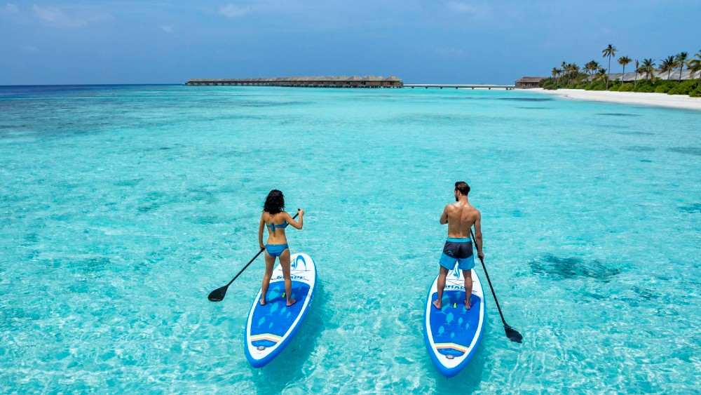 Couple on stand up paddleboards at Hurawalhi Island Resort