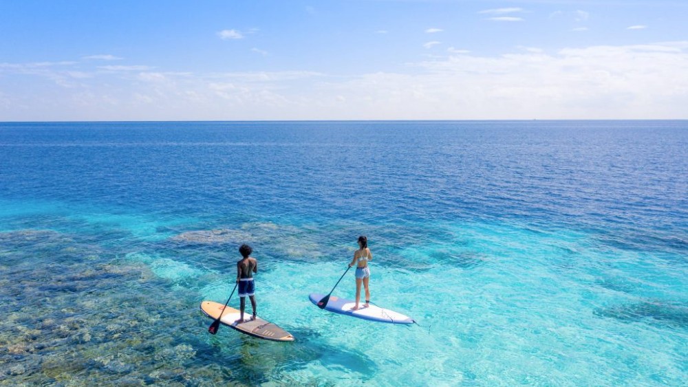 Couple on stand up addleboards at Kagi Spa Island