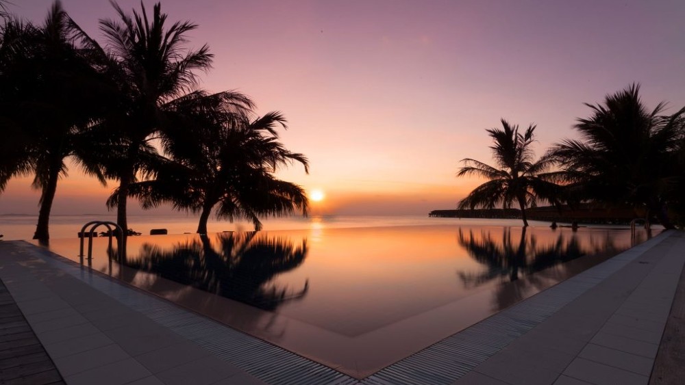 Infinity pool at sunset at Vilamendhoo Island