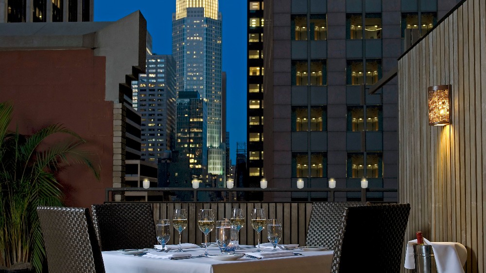 Outdoor dining on the balcony at Kimpton Muse Hotel