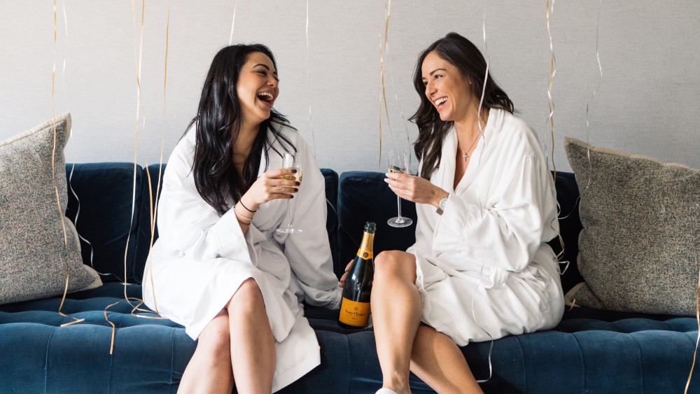 Women drinking champagne in robes at Loews Regency New York