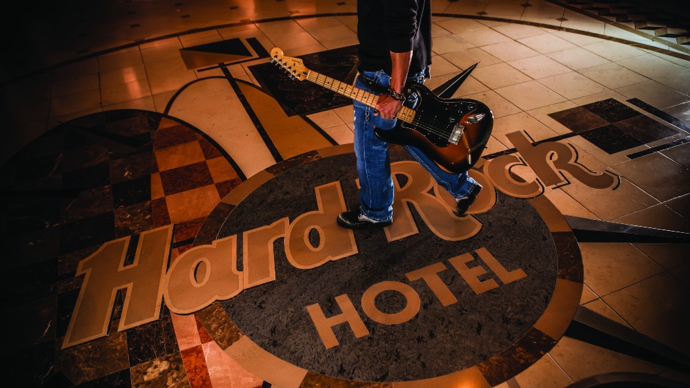 Man cossing the foyer with a guitar at Hard Rock Hotel at Universal