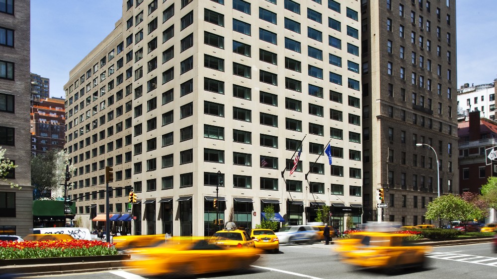 Exterior of Loews Regency New York with yellow cabs passing