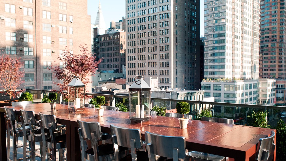 Outdoor dining table on the veranda with views of New York at Kimpton Hotel Eventi