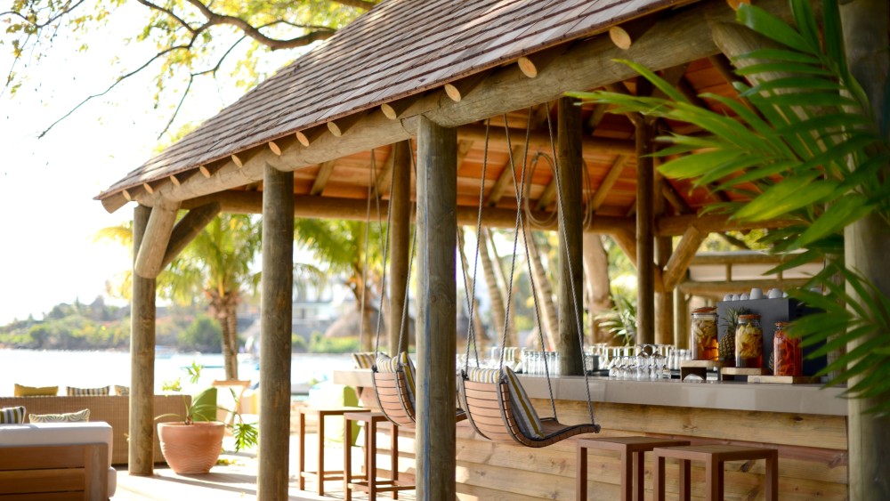 A beach bar surrounded by palms at The Ravenala Attitude