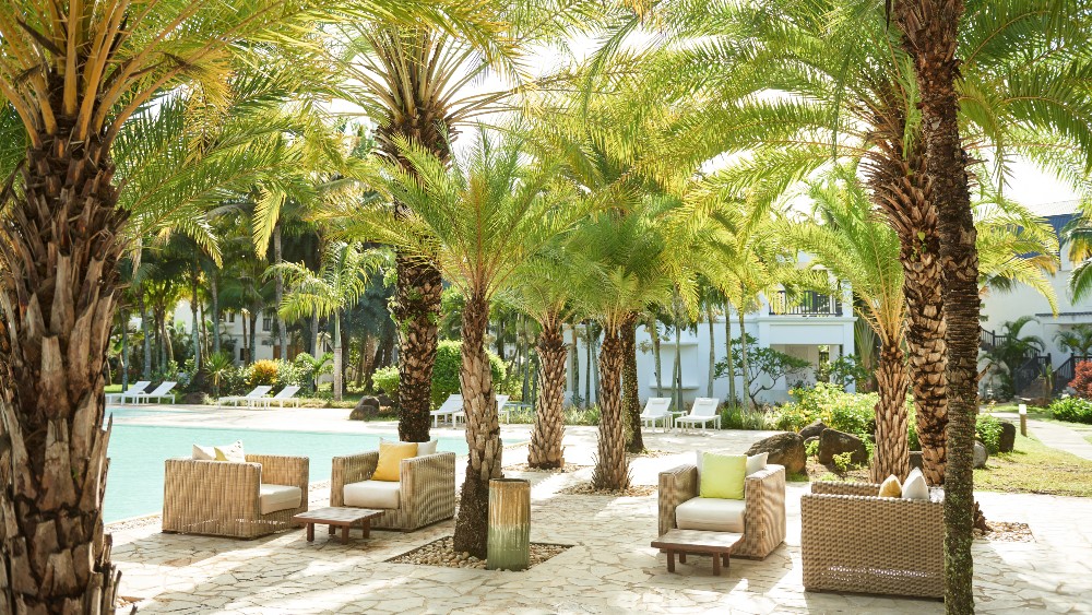 Poolside seating under palms at The Ravenala Attitude