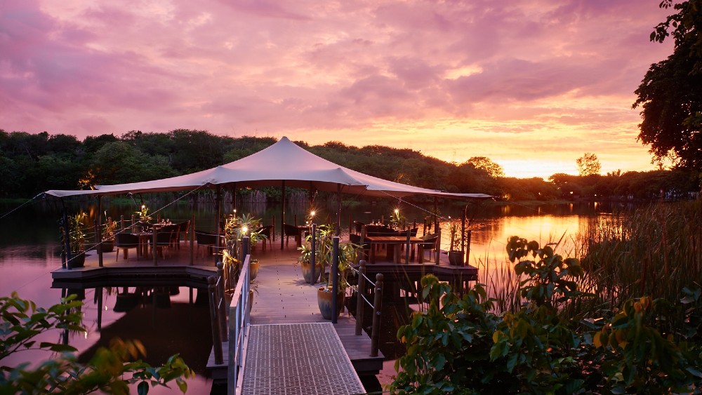 Restaurant over the river at sunset at The Ravenala Attitude
