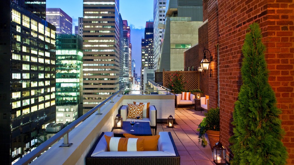 Furnished terrace overlooking New York at dusk from Omni Berkshire Place